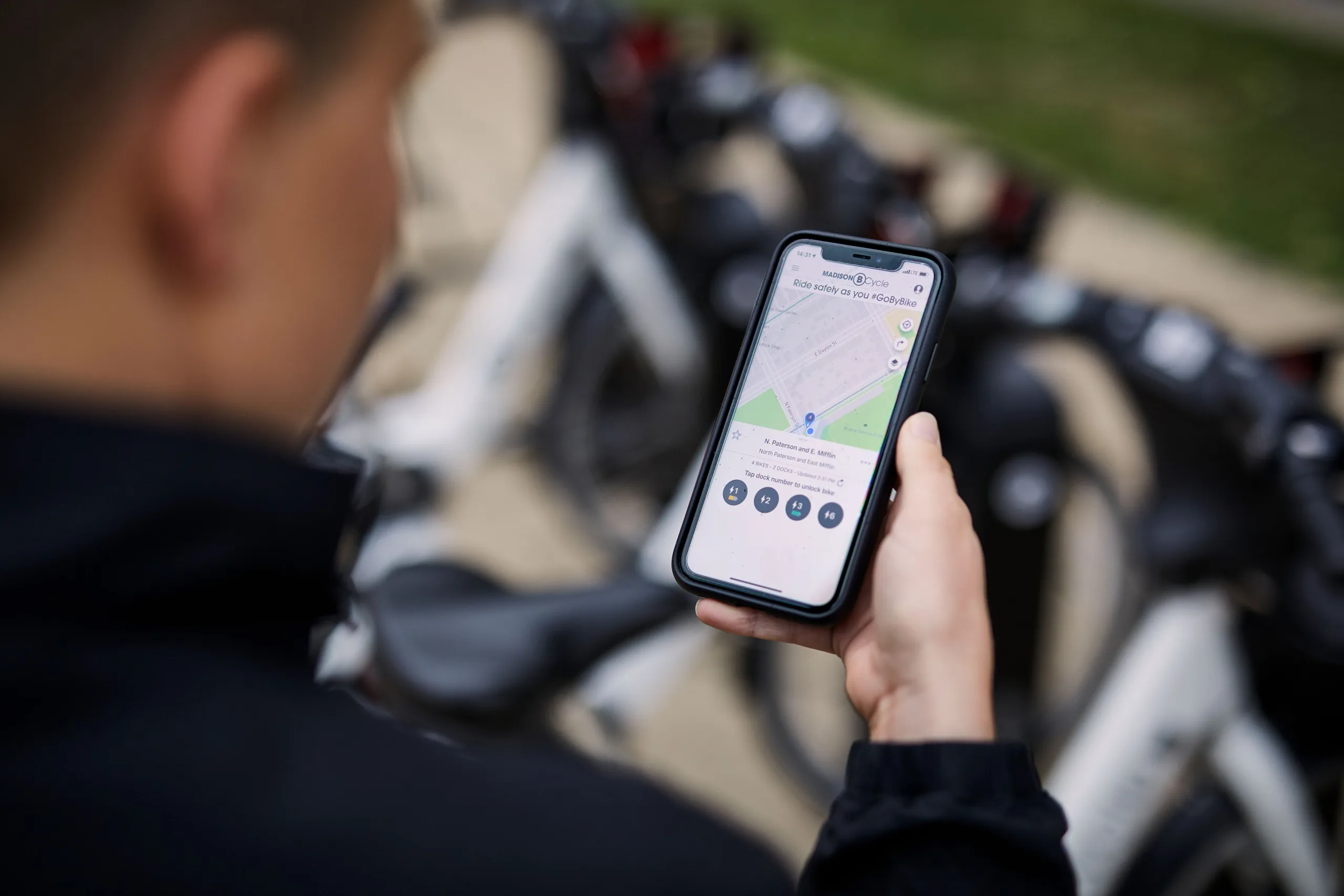 a woman looking at her smart phone to view the BCycle app
