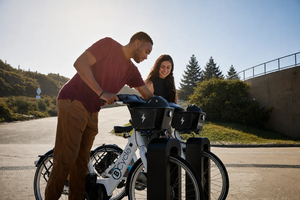 A man showing a woman how to use the BCycle bike share sytem